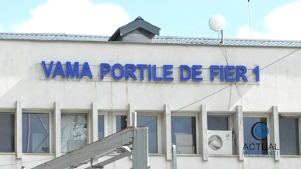 O clădire albă prezintă un inscripție albastră cu textul VAMA PORTILE DE FIER 1 deasupra unor ferestre rectangulare.