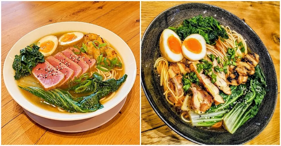 Două boluri de ramen cu tăiței, ouă fierte, legume verzi și felii de carne sau pește sunt așezate pe o suprafață de lemn.