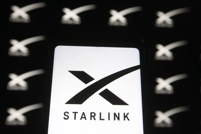 Un ecran de dispozitiv luminos afișează logo-ul alb al Starlink pe un fundal negru, înconjurat de mai multe simboluri similare repetate în fundal.