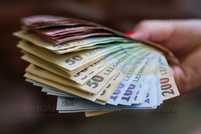 O mână ține un teanc de bancnote de lei desfăcute în evantai.