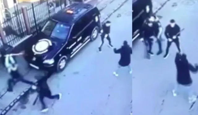 O imagine de supraveghere de sus arată mai mulți oameni care se mișcă pe o suprafață asfaltată lângă un vehicul de culoare închisă.