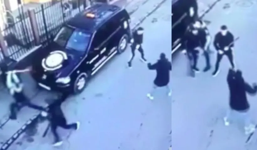 O imagine de supraveghere de sus arată mai mulți oameni care se mișcă pe o suprafață asfaltată lângă un vehicul de culoare închisă.