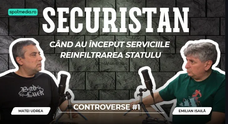 Doi bărbați stau la o masă cu microfoane în fața unui perete de cărămidă gri, purtând tricouri negru și verde.
