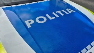 Textul alb cu litere mari este scris pe o suprafață albastră de pe capota unui vehicul.
