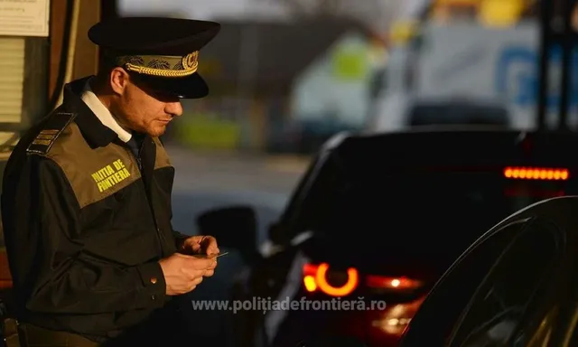 Un agent de poliție în uniformă stă lângă o mașină întunecată într-un cadru exterior.