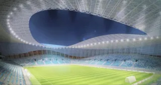 O reprezentare digitală a interiorului unui stadion cu tribune de culoare albastră și un teren de fotbal verde sub o structură de acoperiș curbată.