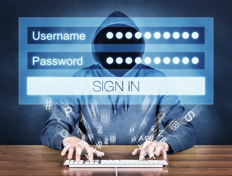O persoană purtând o hanorac cu glugă și fața acoperită stă la un tastatură de calculator în fața unui panou de autentificare digital.