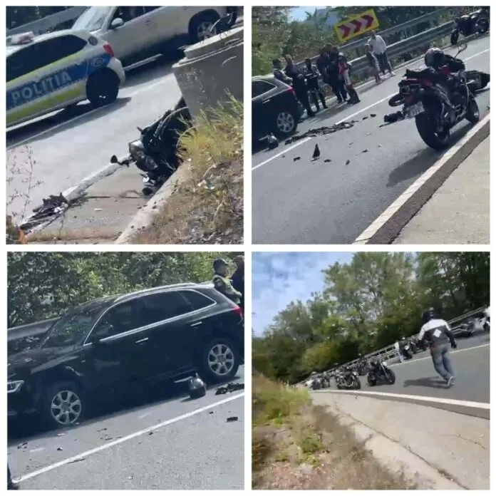Două motociclete, un autoturism negru și o mașină de poliție sunt vizibile pe un drum asfaltat lângă o gardă de protecție și vegetație.