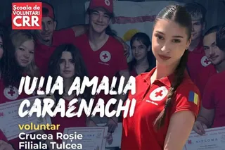 Un grup de tineri purtând tricouri roșii cu simbolul crucii albe stă strâns pentru o fotografie de grup în interior.