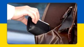 O mână scoate un portofel negru dintr-o geantă maro deschisă.