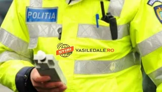 Un agent de poliție poartă o uniformă galbenă reflectorizantă și ține în mână un aparat de testare.