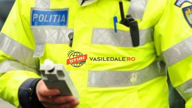 Un agent de poliție poartă o uniformă galbenă reflectorizantă și ține în mână un aparat de testare.