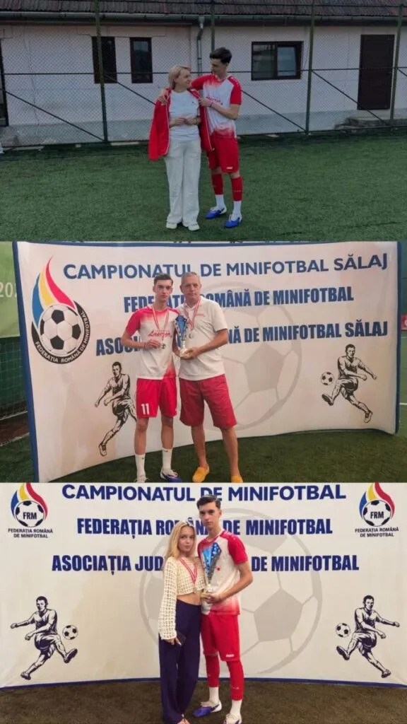 Un bărbat în echipament sportiv roșu și alb și o femeie în haine albe stau în spatele unui banner alb cu grafică de fotbal.