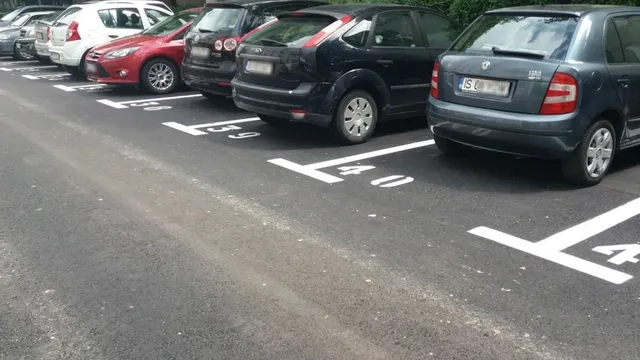 Locuri de parcare de reședință numerotate, cu autoturisme parcate; fotografie ilustrativă furnizată de sursă.