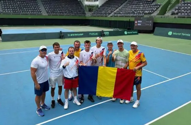 Oamenii stau în rând pe un teren de tenis și țin împreună un steag format din trei culori verticale.