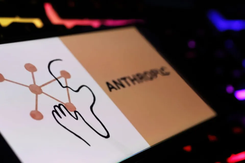 Un card cu logo-ul Anthropic și un desen minimalist al unei fețe sunt așezate pe o suprafață întunecată cu lumini colorate.