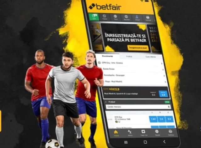 Un telefon mobil afișează o aplicație de pariuri sportive lângă trei bărbați îmbrăcați în echipamente de fotbal pe un fundal negru și galben.