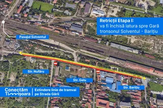 O fotografie aeriană a unei zone urbane cu clădiri, vegetație, șine de tren și câteva etichete text colorate suprapuse pe imagine.