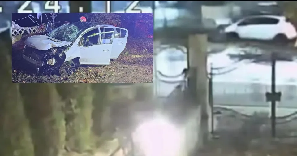 Un autoturism alb cu portierele deschise este situat pe un teren cu iarbă lângă un copac.