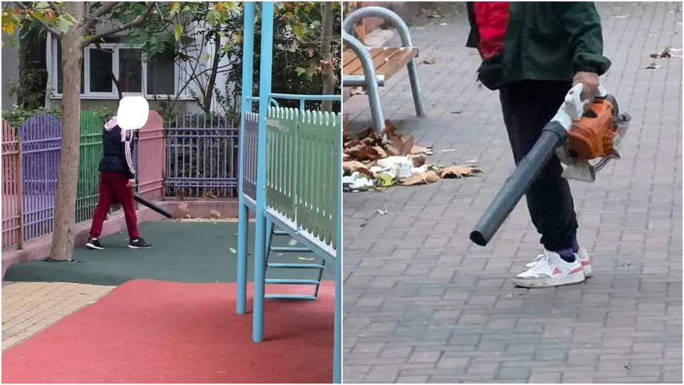 O persoană poartă haine închise și folosește o suflantă de frunze cu motor pe un trotuar pavat lângă un banc.