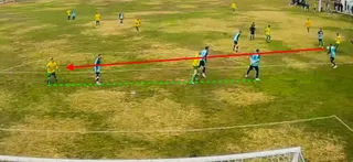 Câțiva jucători de fotbal în echipamente galbene și albastre sunt dispersați pe un teren de fotbal cu iarbă verde.