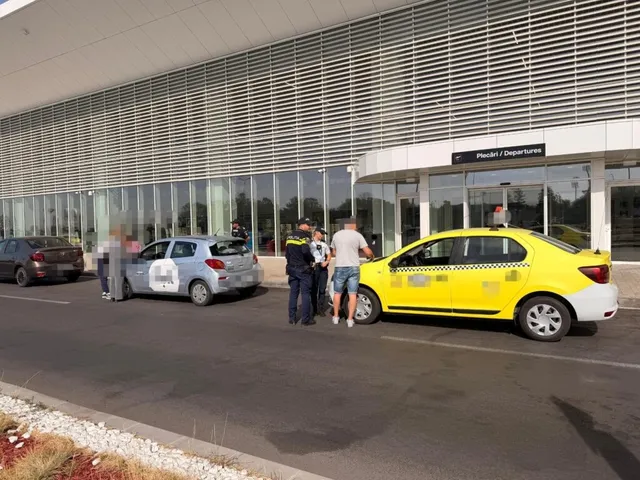 Un grup de persoane stă lângă un taxi galben și o mașină gri în fața unei clădiri cu suprafețe vitrate mari.
