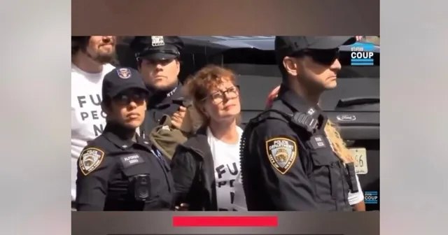 Un grup de polițiști în uniformă neagră stă lângă o femeie cu ochelari și tricou alb într-un spațiu exterior cu un vehicul în fundal.