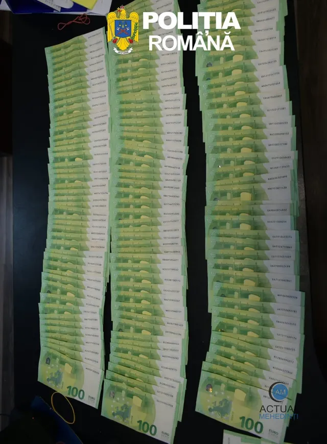 Mai multe coloane de bancnote de o sută de euro sunt așezate pe o suprafață plană închisă.