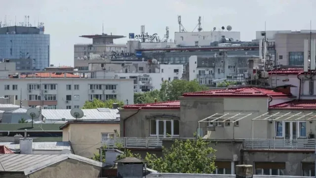 Vederea de la înălțime asupra unor acoperișuri de clădiri urbane cu elemente de utilități și diverse structuri de beton sub un cer deschis.