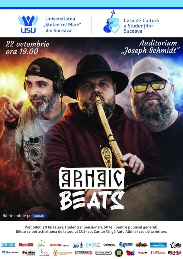 Trei bărbați cu barbă sunt așezați în fața unui fundal întunecat, cel din mijloc ținând un instrument muzical lung din lemn.