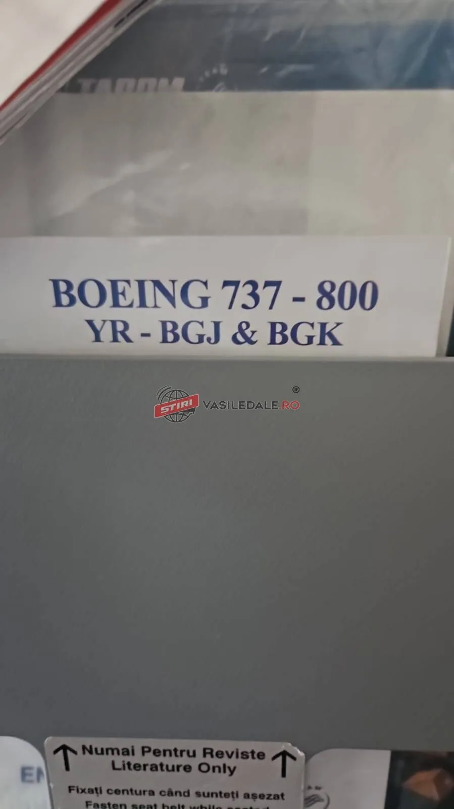O etichetă albă afișează textul albastru Boeing 737 - 800 și YR - BGJ & BGK deasupra unei suprafețe gri.