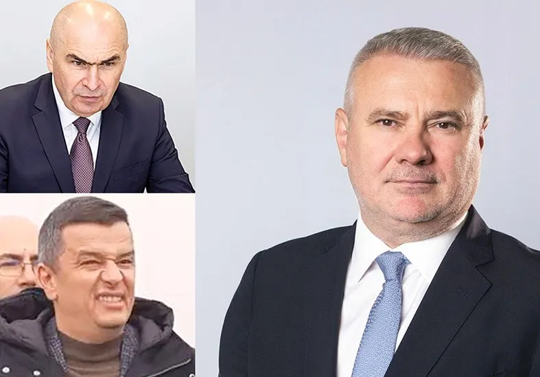 Un bărbat cu părul scurt și cămașă albă poartă un costum închis și o cravată albastră, fiind prezentat într-un portret de tip bust.