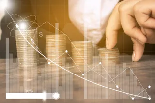 O mână atinge un stivă de monede aurii de pe o suprafață plană, suprapusă de grafice financiare și linii de tendință albe.