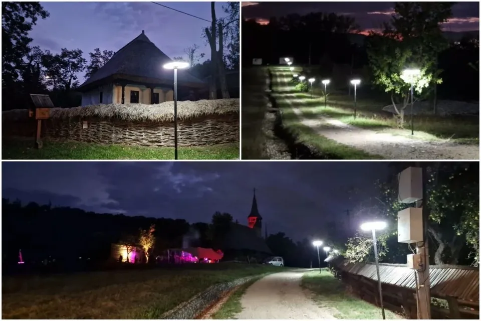 Mai multe felinare de stradă aprinse sunt instalate de-a lungul unui drum de pietriș și lângă o clădire tradițională sub un cer nocturn.
