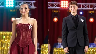 O femeie într-o rochie roșie cu numărul 5 și un bărbat într-un costum negru cu numărul 8 stau în fața unui fundal cu lumini.