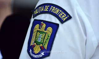 Un emblema brodată cu un acvile și textul POLIȚIA DE FRONTIERĂ este atașată pe o uniformă albă.