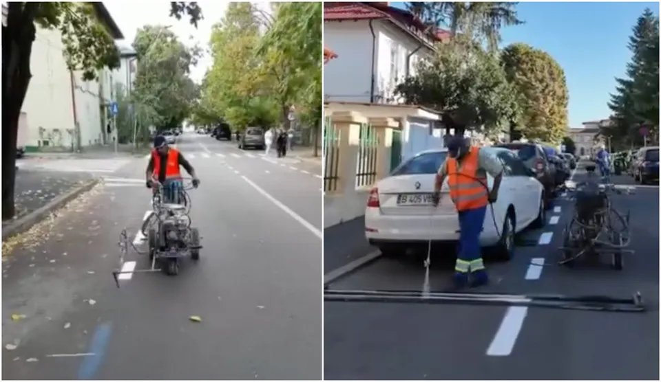 Un bărbat cu vestă portocalie și cască conduce un vehicul cu trei roți pe un drum asfaltat lângă copaci.
