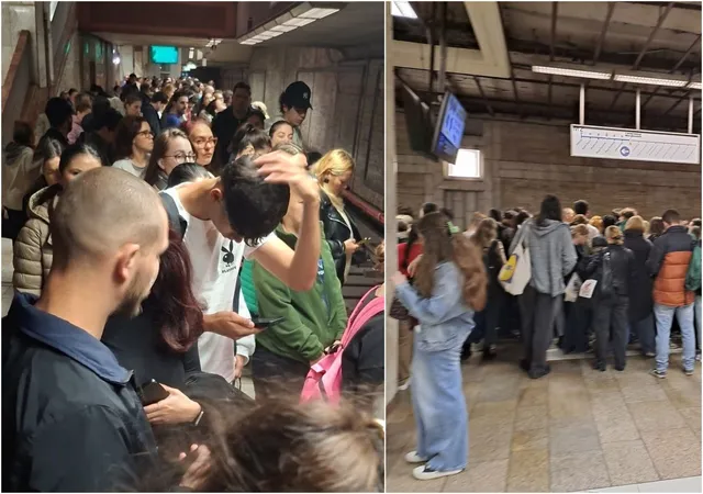 Mulți oameni stau în picioare într-o stație de metrou, unii folosind telefoane mobile, sub lumini artificiale de interior.