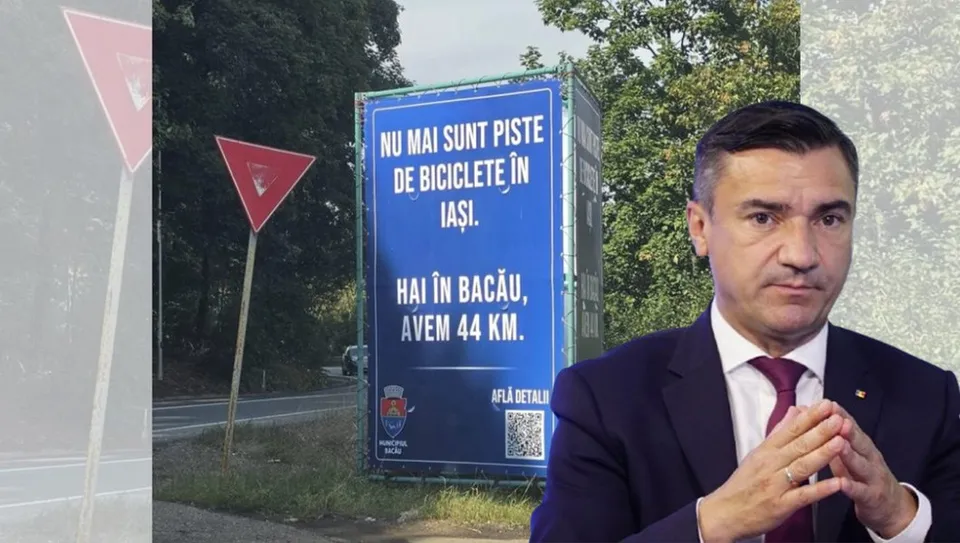 Un bărbat într-un costum închis și cravată purtând o manșetă albă stă în prim-plan, având un panou publicitar albastru și copaci în fundal.