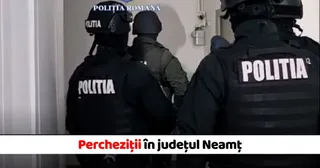 Patru persoane purtând uniforme negre și căști cu inscripția POLITIA stau cu spatele într-un spațiu interior cu un perete alb.