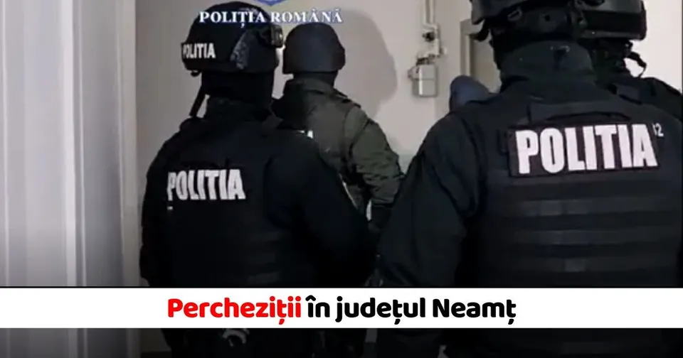 Patru persoane purtând uniforme negre și căști cu inscripția POLITIA stau cu spatele într-un spațiu interior cu un perete alb.