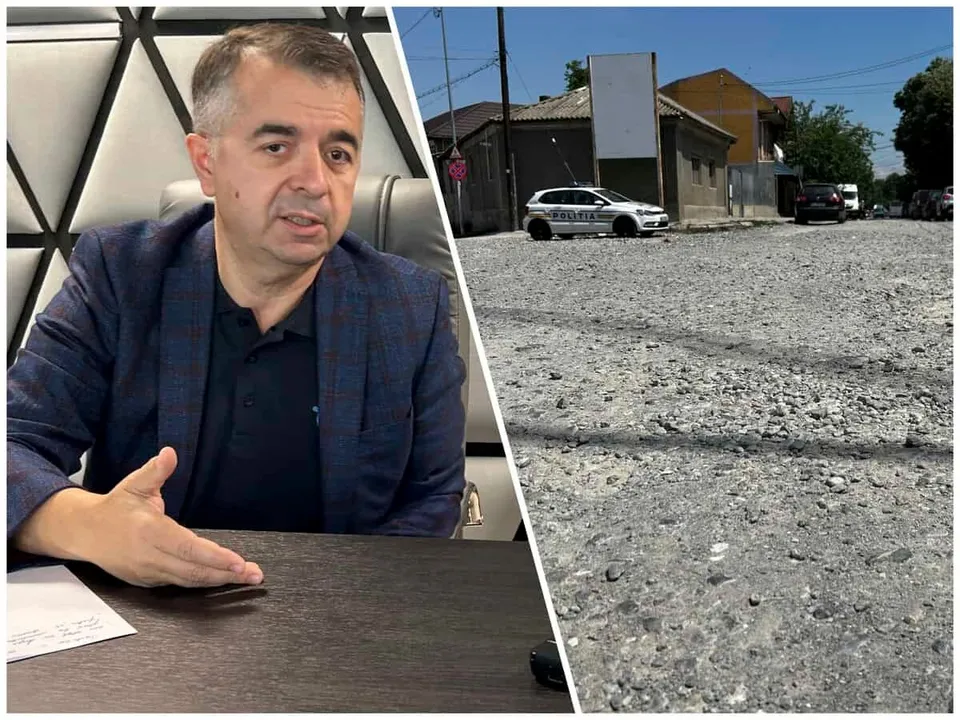 Un bărbat cu sacou și cămașă stă la o masă, în timp ce în partea dreaptă se vede o stradă cu pietriș și un autoturism alb.