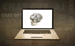 O imagine cu un laptop deschut afișând o ilustrație a unui creier uman cu piese mecanice de ceasuri și roți dințate, pe un fundal texturat cu textul CHAT GPT.