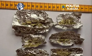 Cinci bucăți de folie de aluminiu conținând substanțe vegetale sunt așezate pe o suprafață lângă o riglă galbenă.