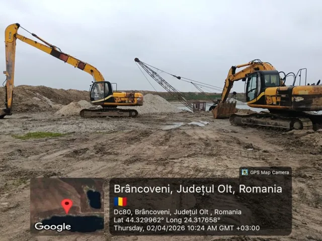 Două excavatoare galbene lucrează pe un teren de nisip sub un cer înnorat.