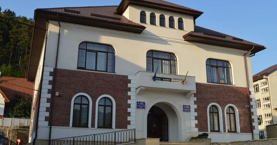 O clădire cu fațadă din cărămidă și zone albe, având ferestre arcuite la parter și ferestre dreptunghiulare la etaj sub un acoperiș înclinat maroniu.