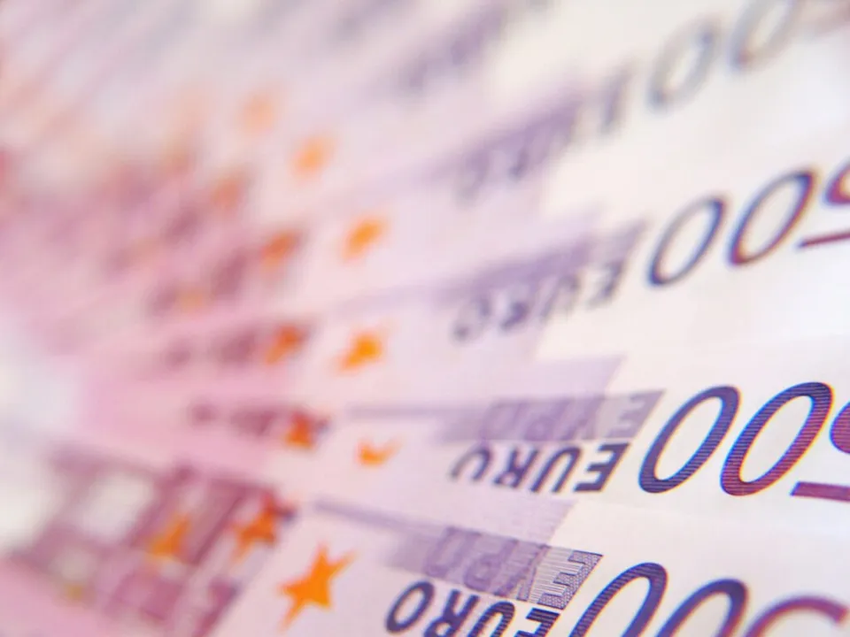 Detalii de pe bancnote de euro cu numărul 500 și simboluri de stele, prezentate într-un unghi înclinat și cu focalizare selectivă.