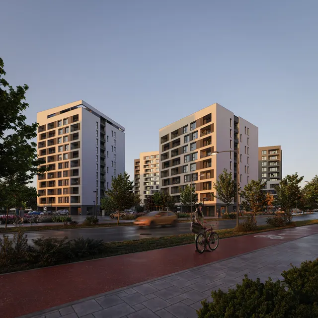 Două clădiri rezidențiale înalte de culoare deschisă sunt situate lângă o stradă cu o pistă pentru biciclete și vegetație în prim-plan.