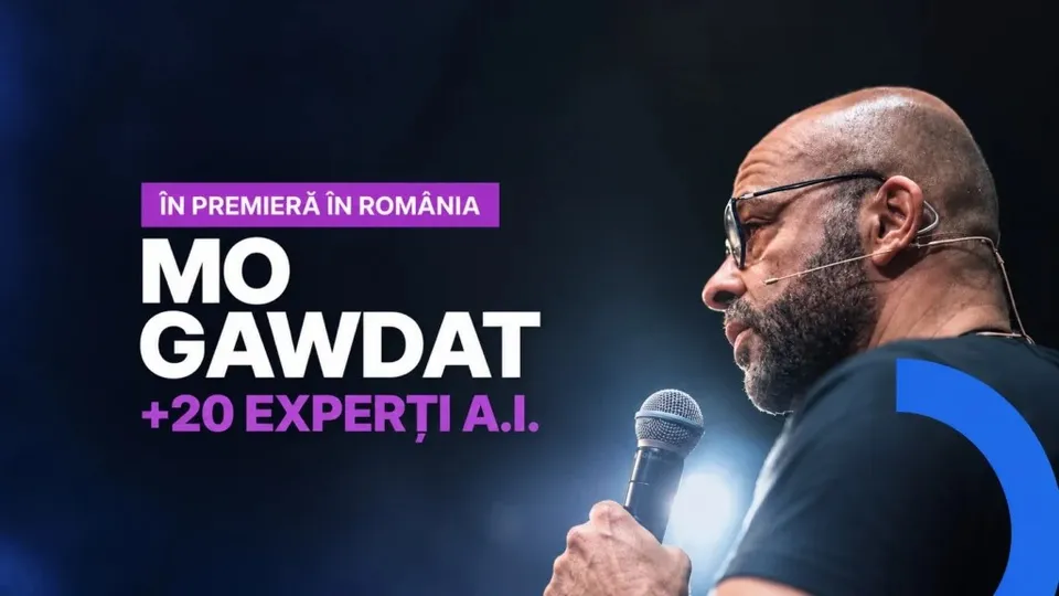Un bărbat cu ochelari și barbă ține un microfon în mână, fiind surprins în profil pe un fundal închis cu text colorat.