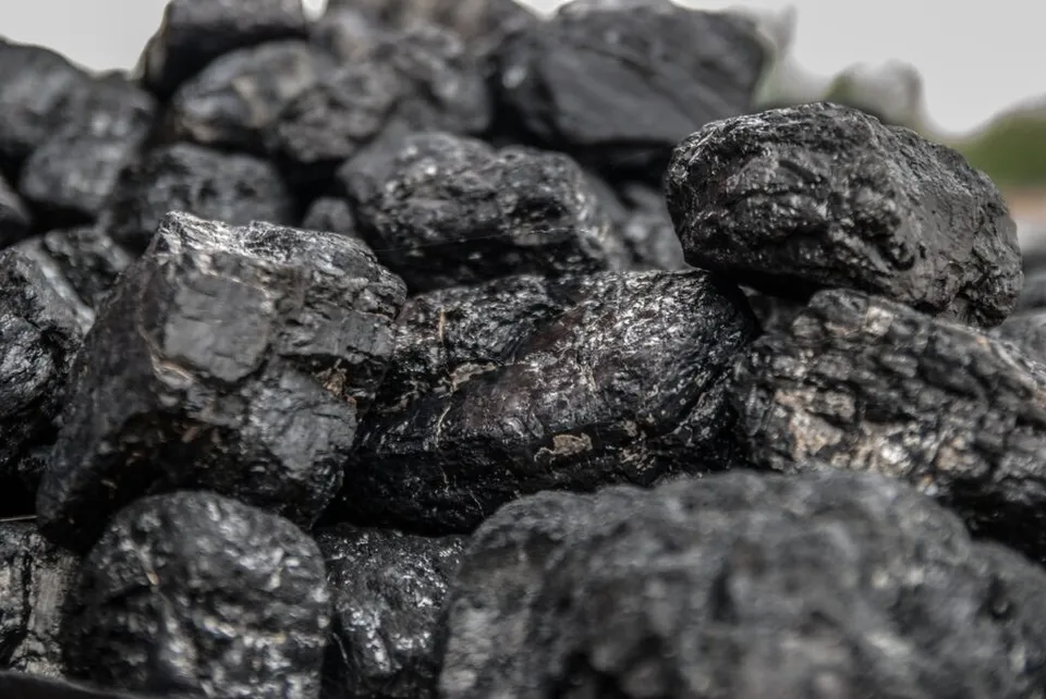 Un grup de pietre negre, neregulate și texturate este așezat într-o grămadă.
